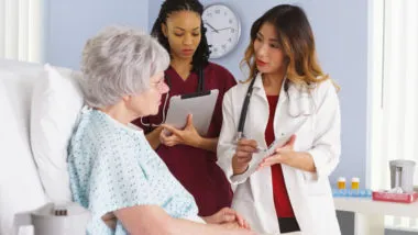 Patient talking to doctors in hospital bed