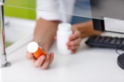 Pharmacist with medication in hand at the pharmacy