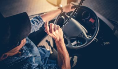A truck driver talks on a CB.