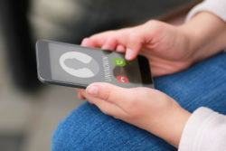 A smartphone shows an unknown number for an incoming call.