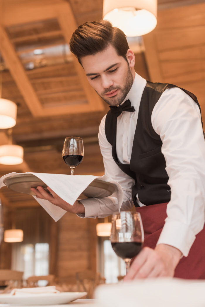 Firebirds restaurant server placing wine on a table