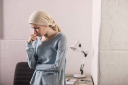 Woman with cancer standing in hospital room