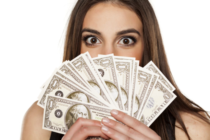 woman holding class action settlement money