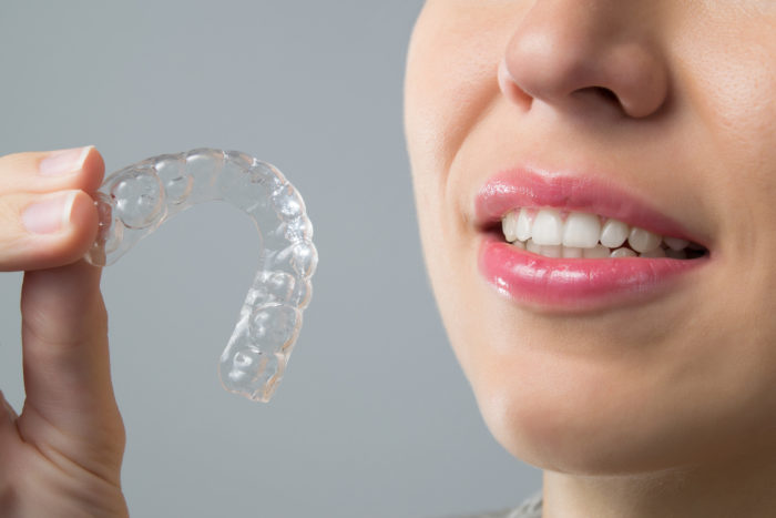 woman holding invisalign braces