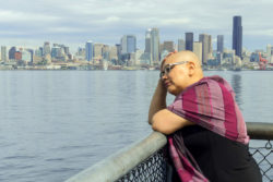 A woman with cancer stands on waterfront