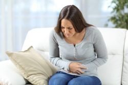 Young woman holding stomach with pain
