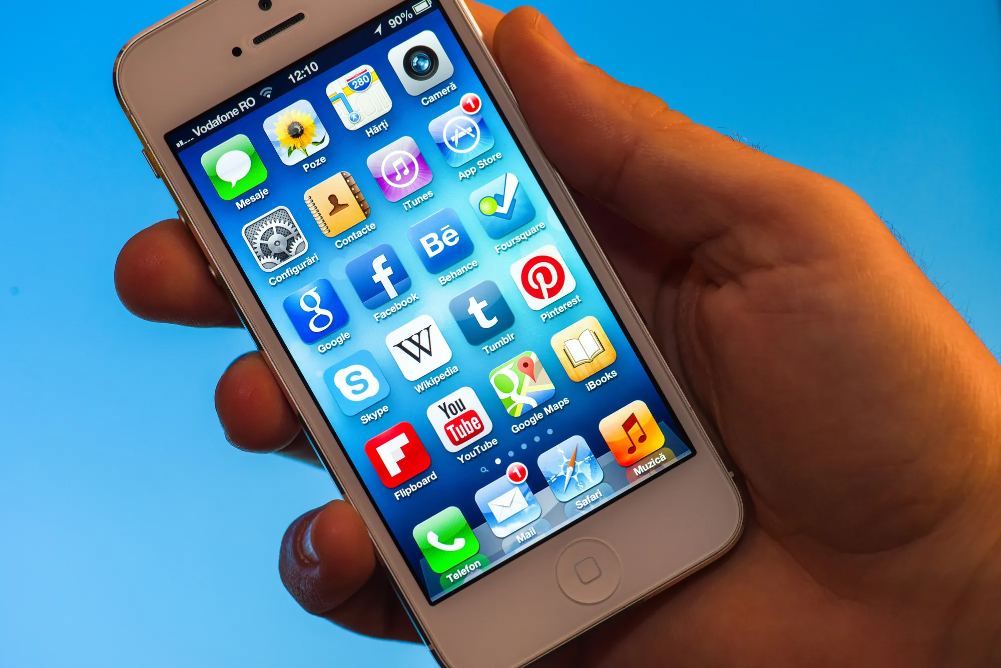 person holding an apple iphone 5