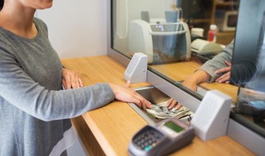 Bank teller gives money to customer.