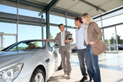 A couple talks to a car dealer.