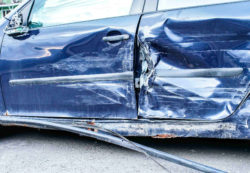 Close up o f the side of a wrecked blue car