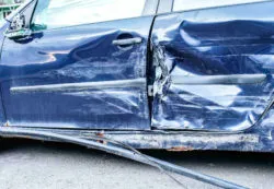 Close up o f the side of a wrecked blue car