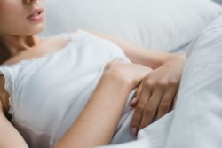 Cropped image of woman holding stomach in pain