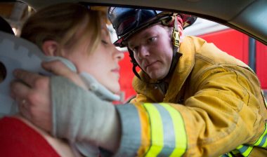 Firefighter helping injured woman in car