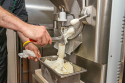 Ice cream pours out of a machine.