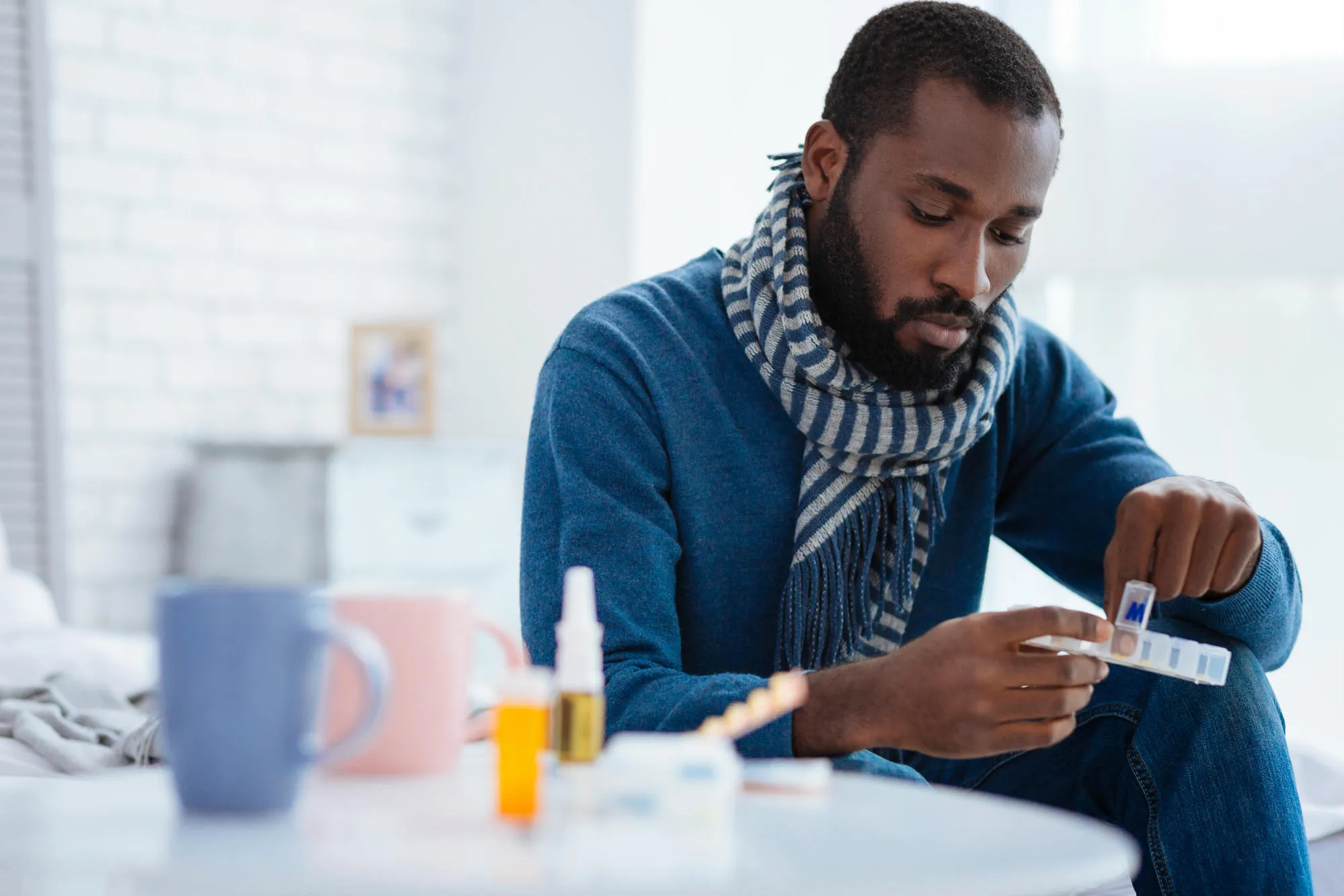 Man taking pill from pill box