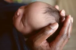 Newborn baby held by father