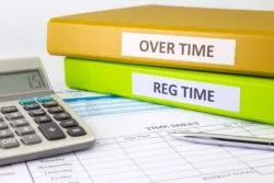 Overtime and regular time notebooks on table