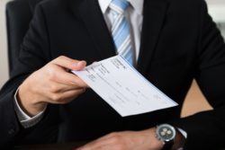 Businessman handing a paycheck