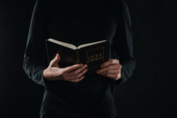 New York Catholic prioest cradles a Holy Bible.