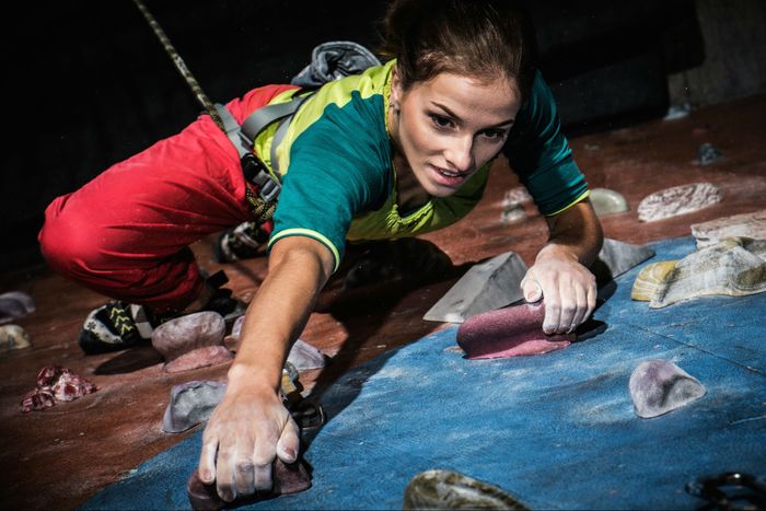 A woman climbs an indoor route.