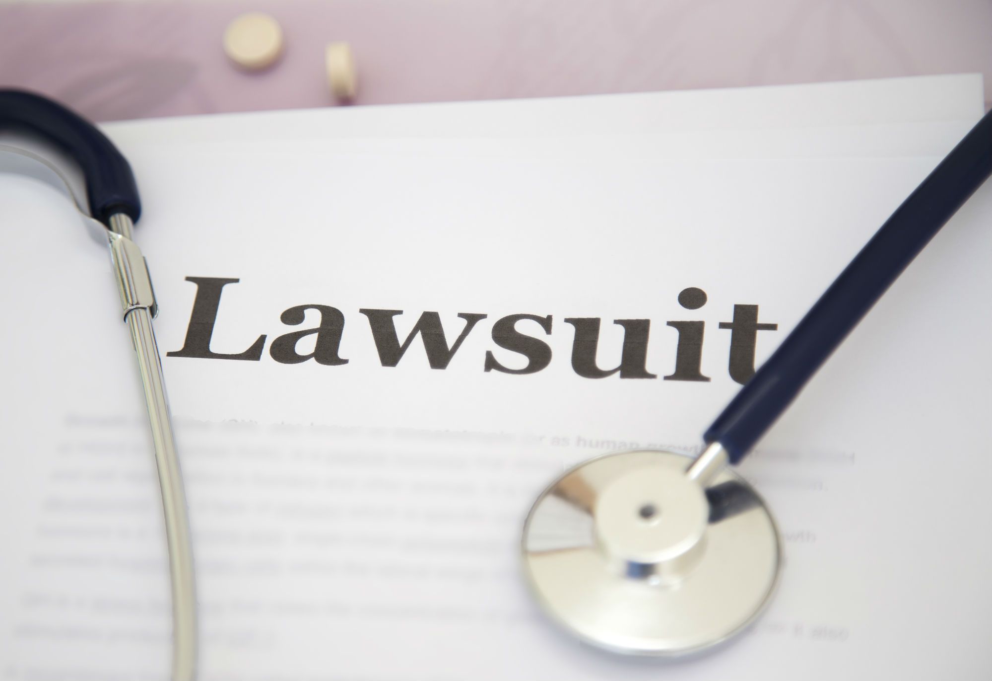 Stethoscope draped over papers labeled "Lawsuit"