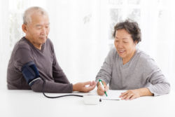 A woman takes a man's blood pressure.