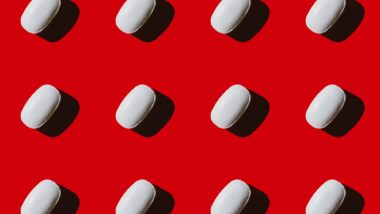 White pills on red background