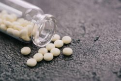 White pills spilling on grey background