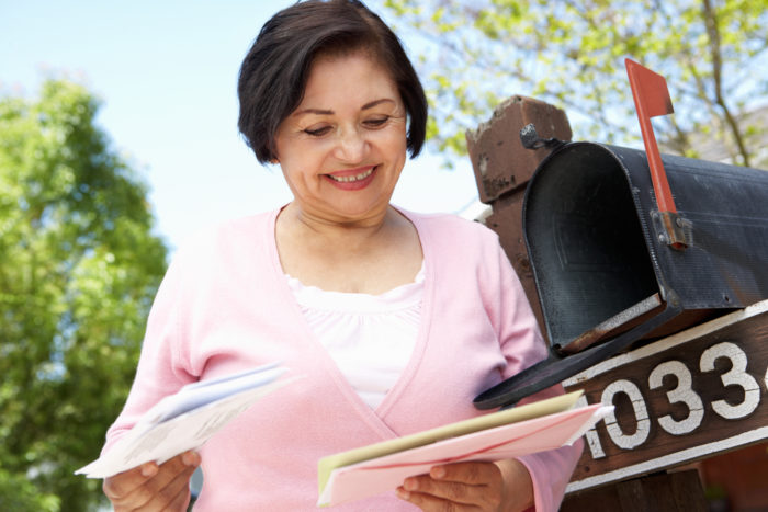 woman checking mailbox and receiving a FTC refund check