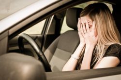 Woman in car after car accident, upset