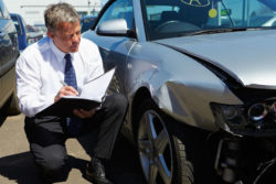 insurance adjuster examines the damage to a vehicle that was ust in a rear end collision