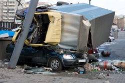 Totaled car is crushed by a truck