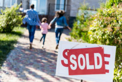 A family runs toward a recently sold house.