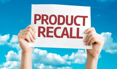 Hands holding product recall sign