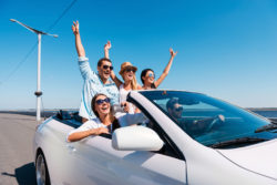 Five people ride in a convertible.