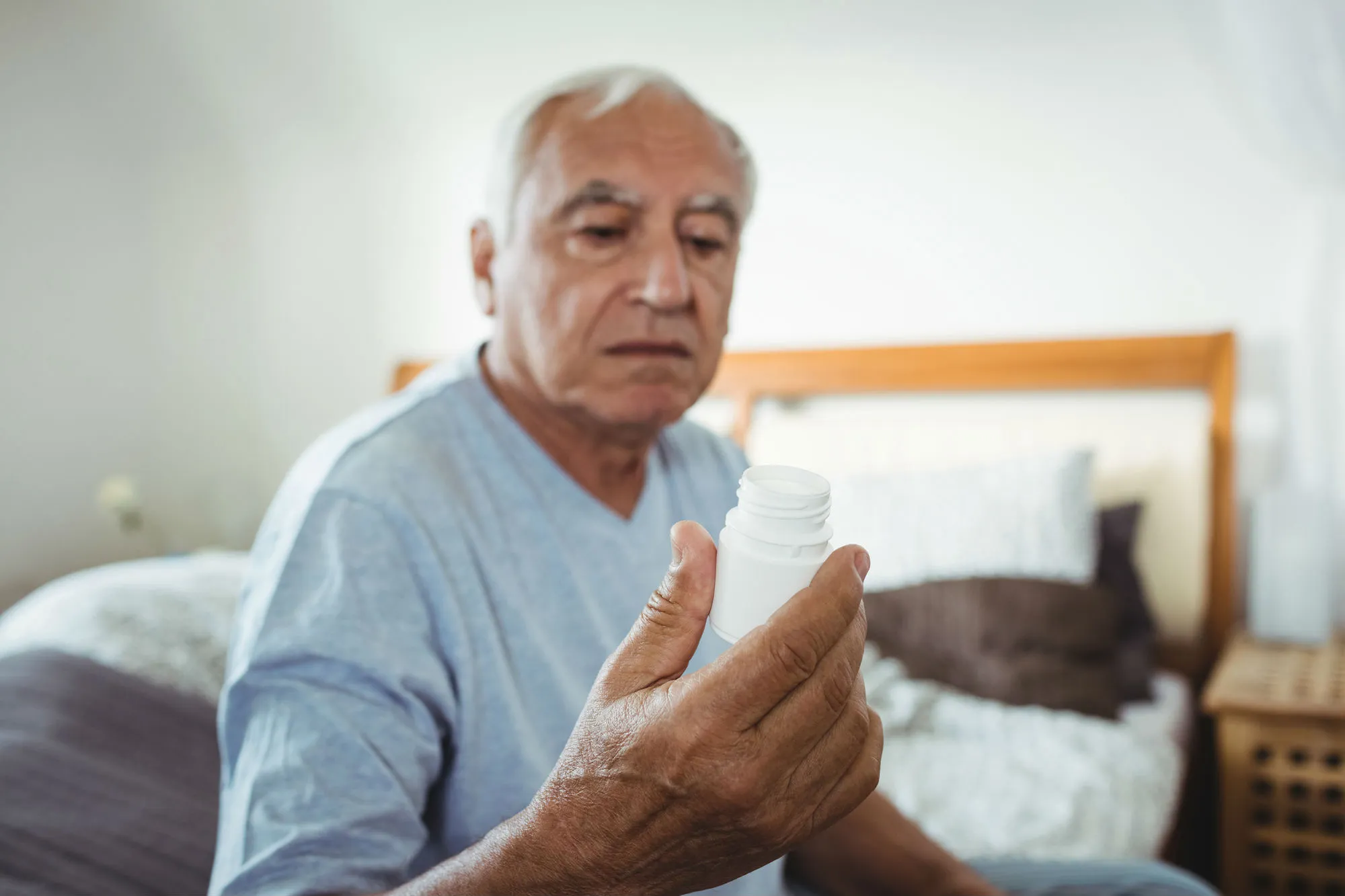 Senior man looking at pill bottle