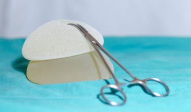 Two textured breast implants and a hemostat