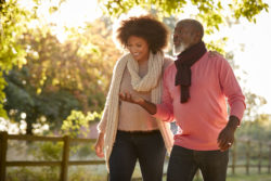A woman and man walk in a park.