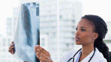 woman doctor looks at x-ray of female patient with symptoms of breast implant illness