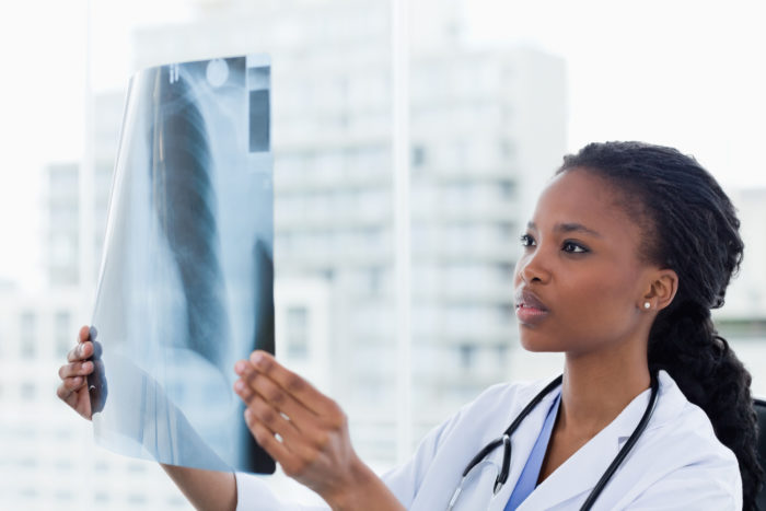 woman doctor looks at x-ray of female patient with symptoms of breast implant illness