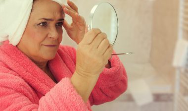 Woman looking at herself in the mirror in bathroom