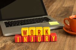 Work injury sign by laptop and coffee