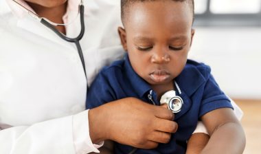 Baby being examined in clinic with stethoscope