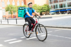 A man making a delivery on a bicycle
