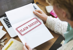 Woman opening claim denied letter