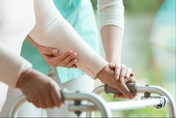 Close up of nurse helping woman with walker