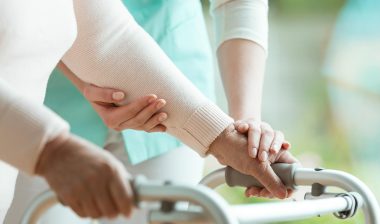 Close up of nurse helping woman with walker