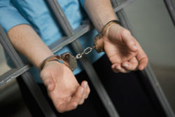 Criminal handcuffed behind bars