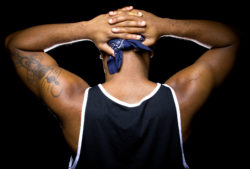 A man holds his hands behind his head.
