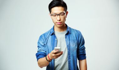 A young man checks his phone.